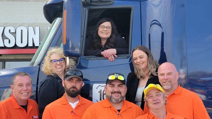 Group of truck drivers smiling near a truck