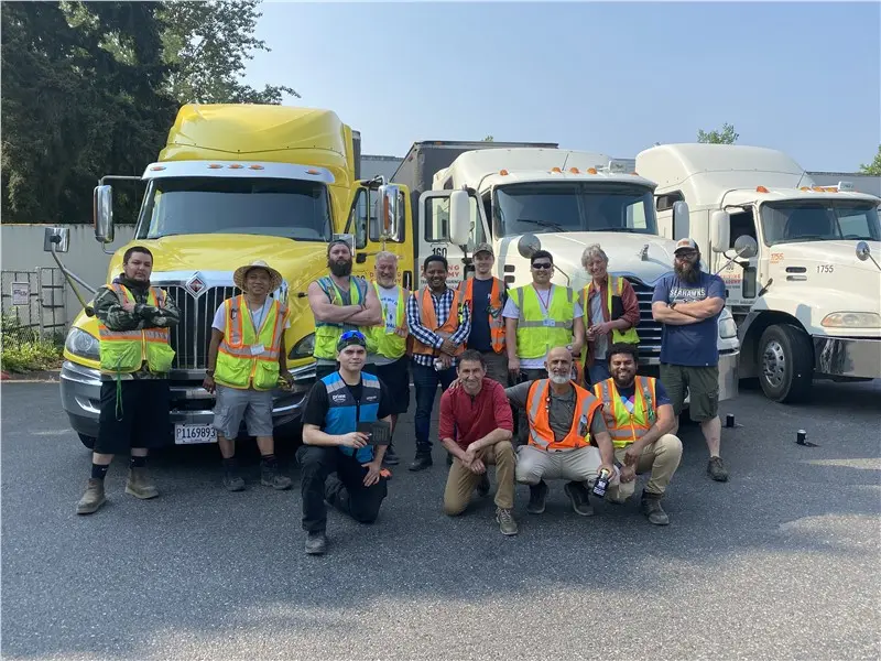 Group of truck drivers standing in front of trucks