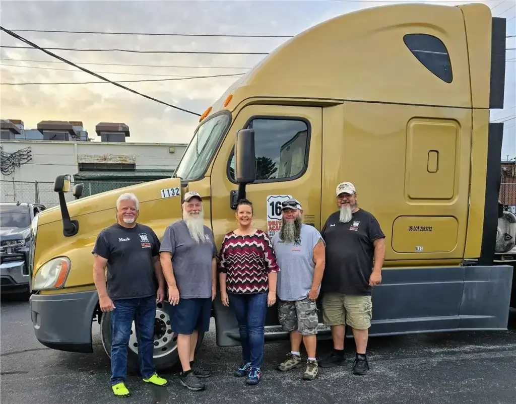 Graduated students standing beside a truck