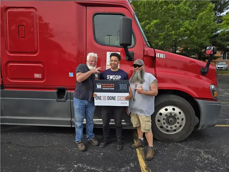 Three men celebrating by a red truck
