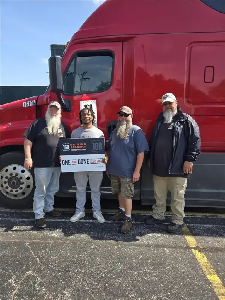 Four people standing beside a red truck