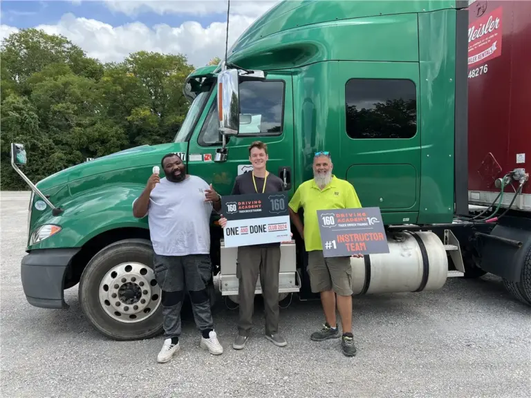 Graduated students posing with green truck