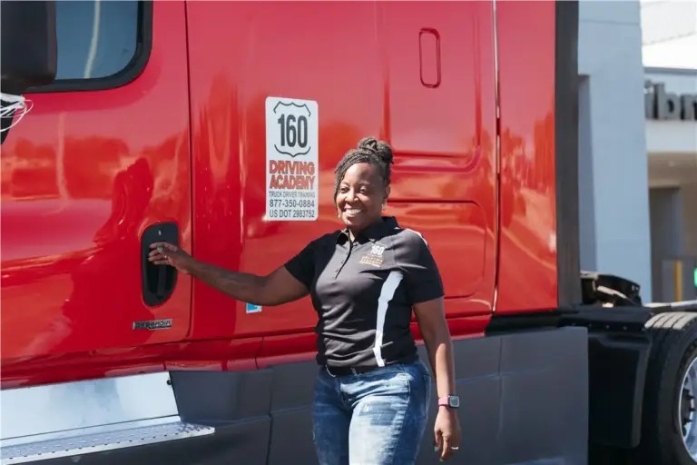 Woman smiling, standing beside a red truck