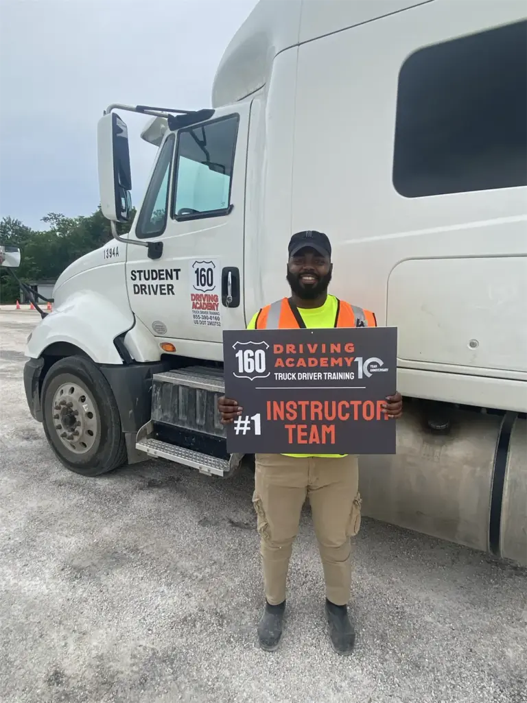 Instructor holding sign beside training truck