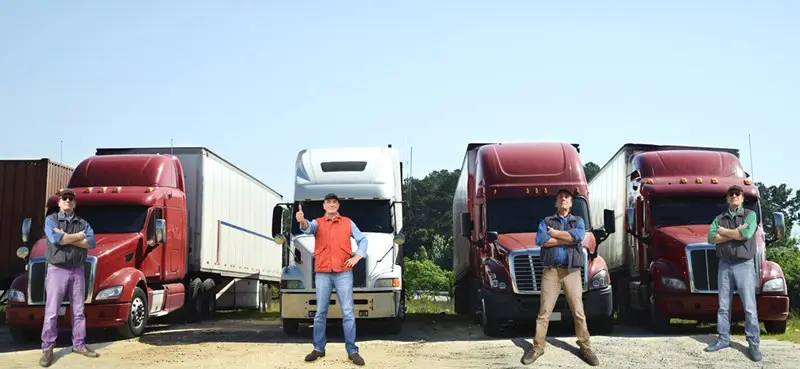 Truck drivers standing in front of semi-trucks