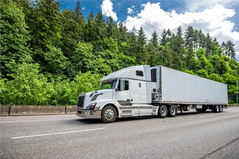 white semi truck highway forest