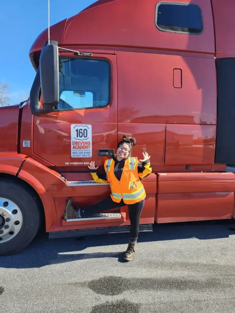 Woman posing next to red truck, smiling widely
