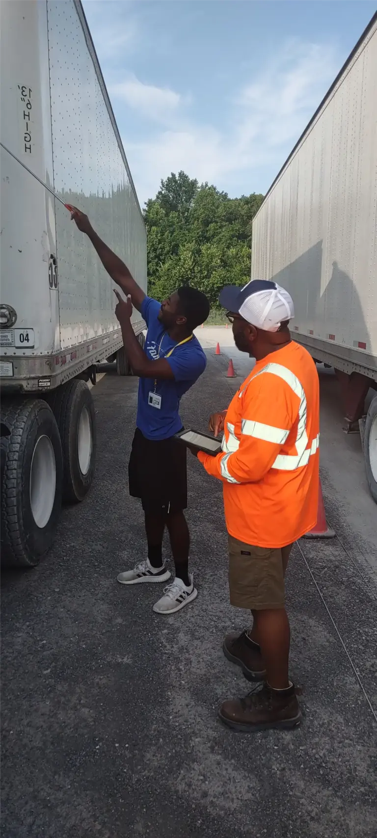 Two workers inspecting trailers outdoors